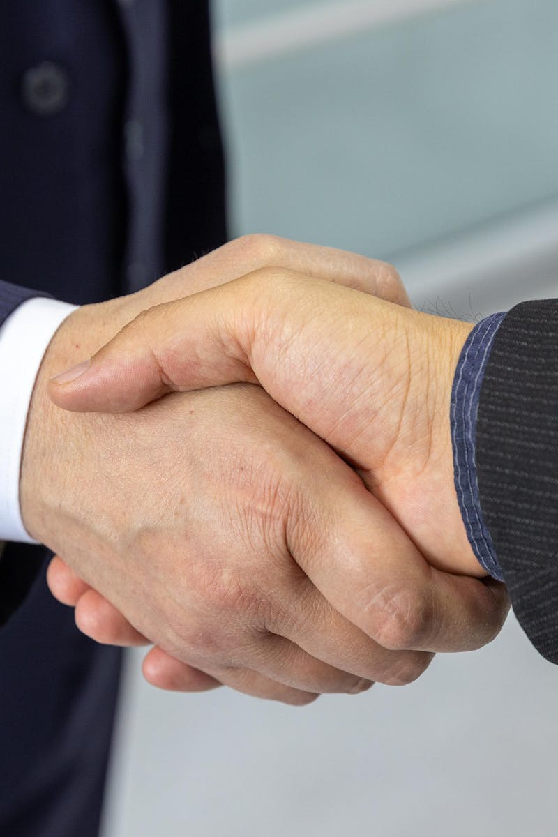 Close-up of two business professionals shaking hands, symbolizing partnership and collaboration.